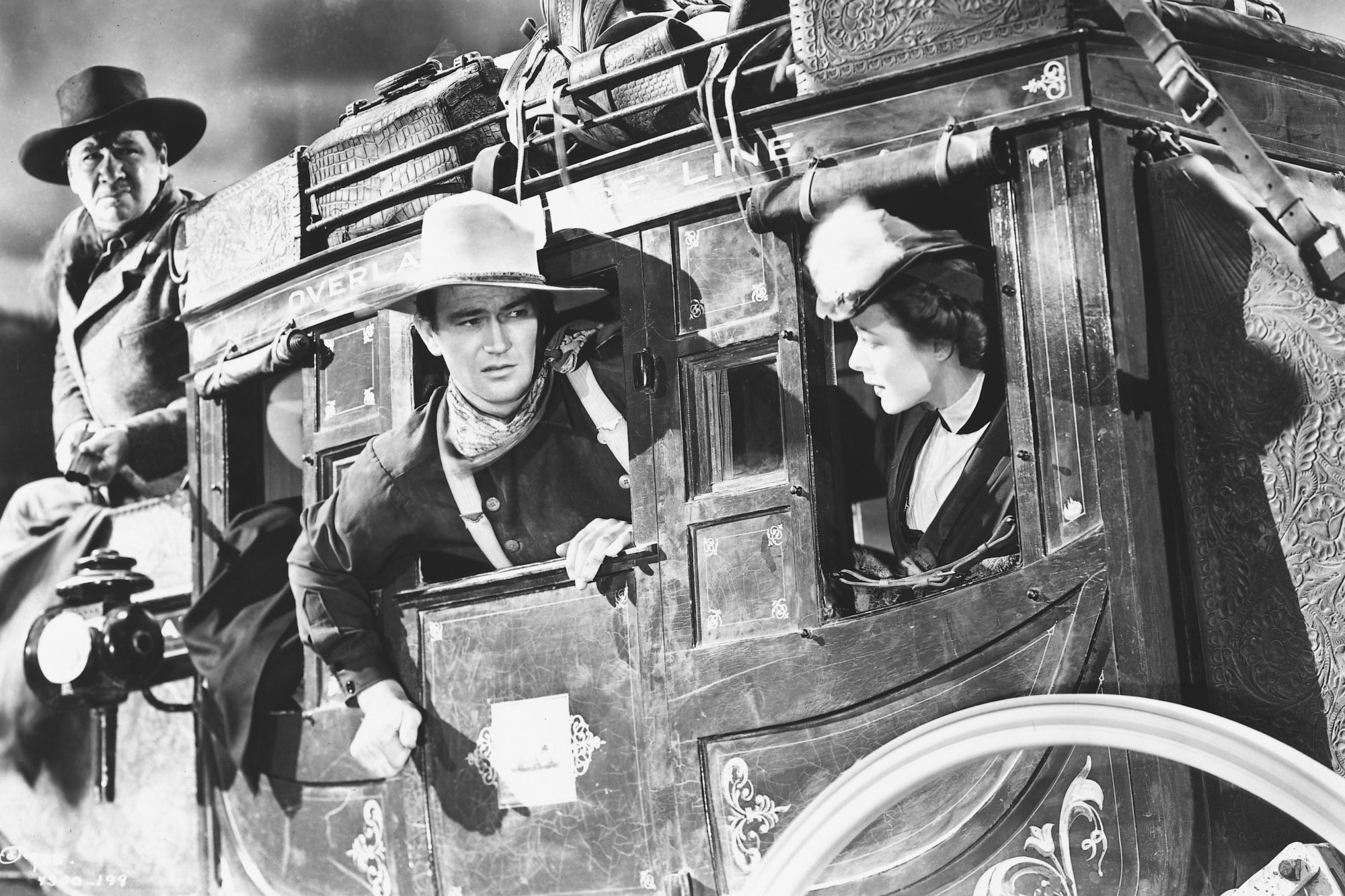 'Stagecoach' John Wayne as Ringo Kid and Louise Platt Mrs. Lucy Mallory in a black-and-white picture of them riding inside of the stagecoach
