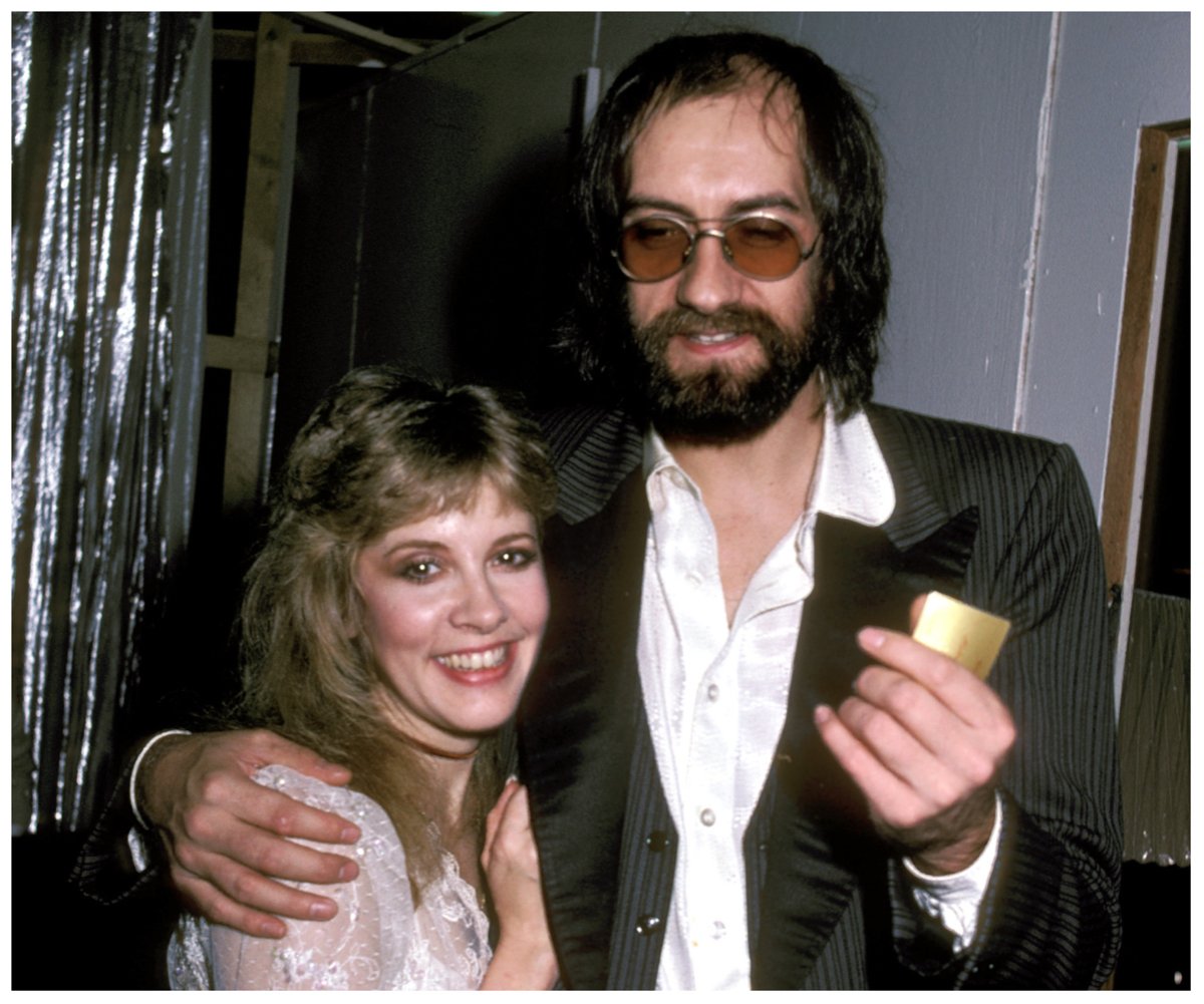Stevie Nicks and Mick Fleetwood, who once had an affair, smile with their arms around each other.