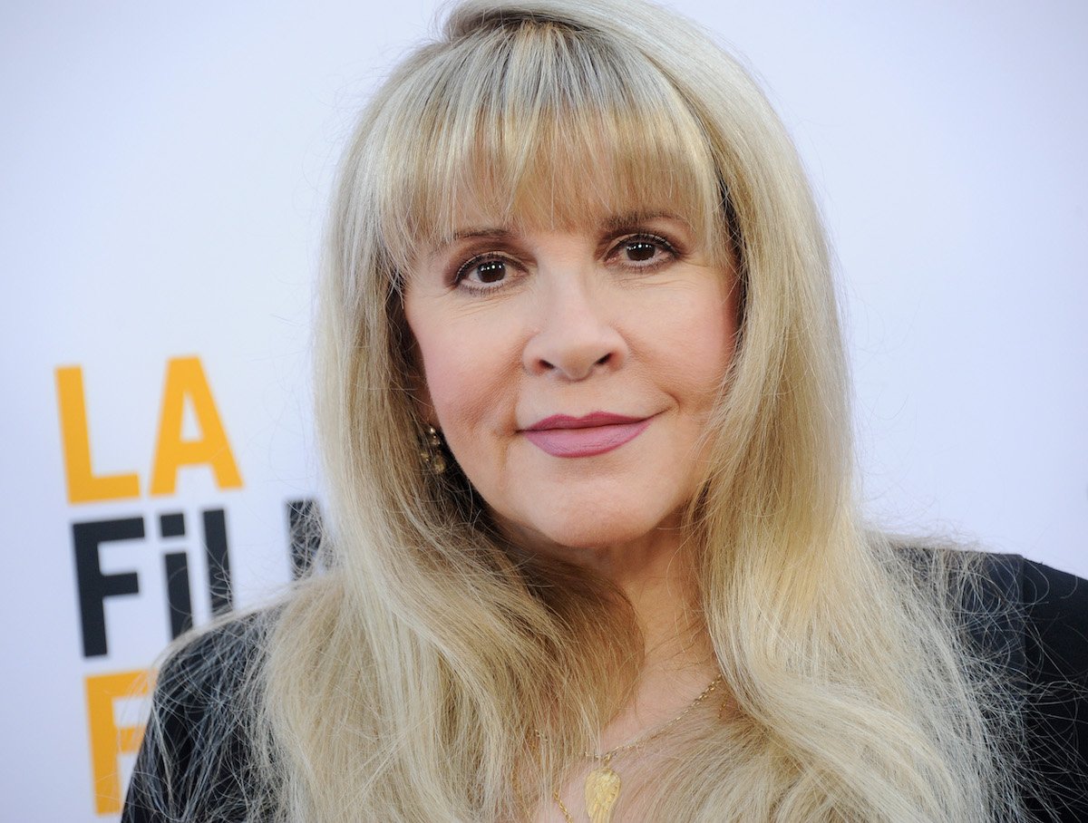 Stevie Nicks, who has had relationships with several famous ex-boyfriends, smiles and poses at an event.