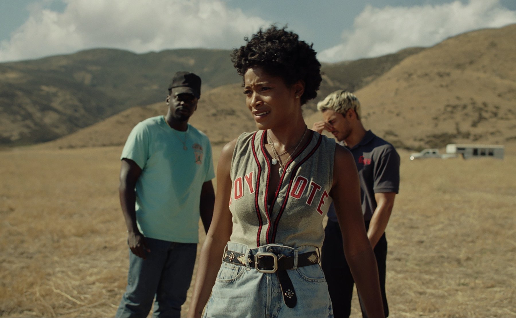 Daniel Kaluuya as OJ Haywood, Keke Palmer as Emerald Haywood, and Brandon Perea as Angel Torres in 'Nope,' which will be available to stream in November 2022. The characters are standing in the middle of a sandy landscape.