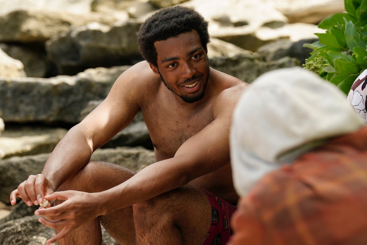 Dwight Moore sits and talks to another castaway on 'Survivor 43'.