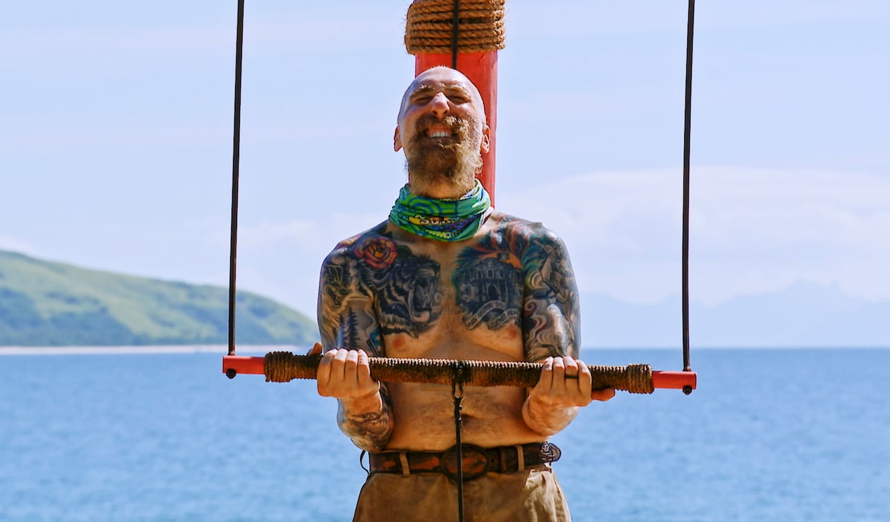 Mike 'Gabler' Gabler cringes as he holds up a bar in an endurance challenge on 'Survivor'.