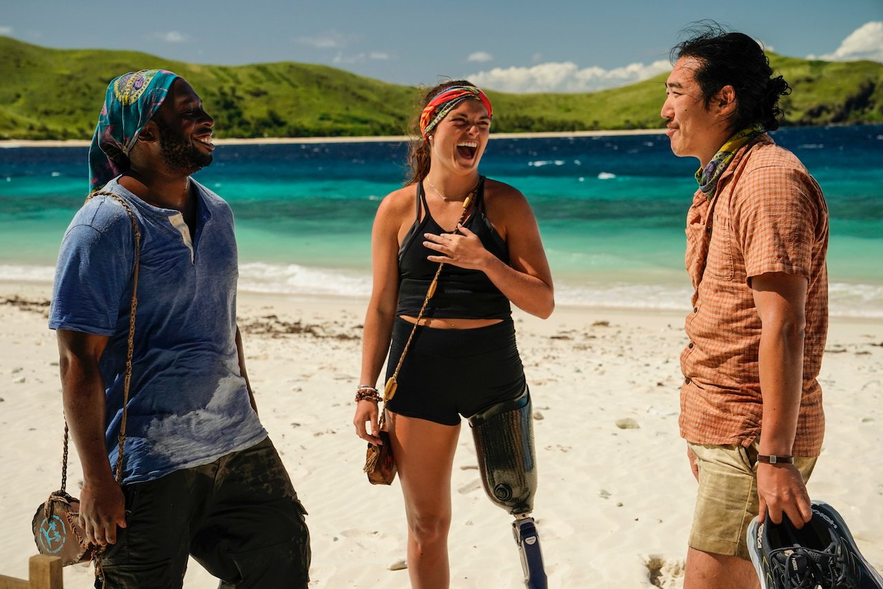 (L-R): James Jones, Noelle Lambert and Owen Knight stand on the beach talking on 'Survivor 43' 