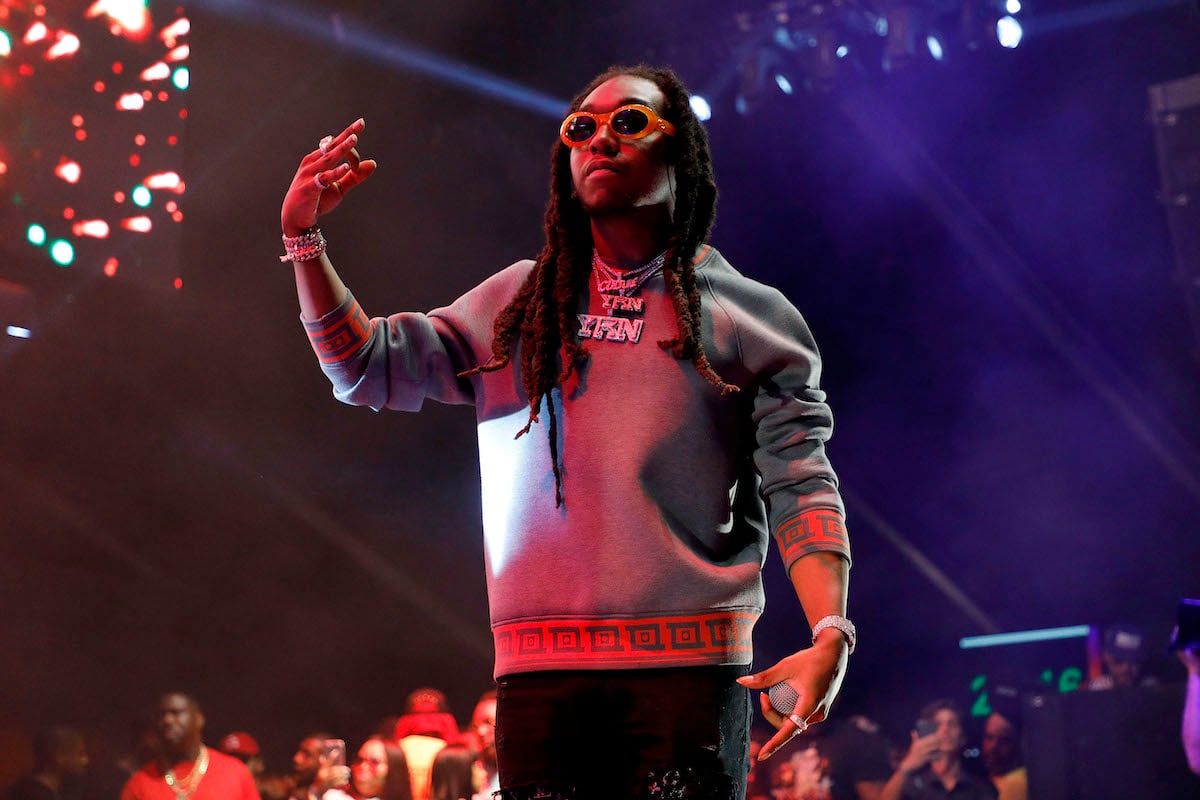 Takeoff of the Migos in a grey sweater performs on stage, increasing his net worth