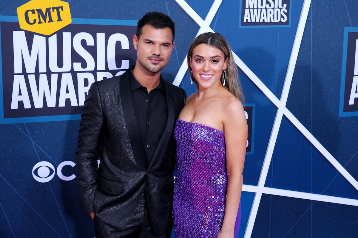 Taylor Lautner and his wife Taylor Dome smile for the camera at the CMAs