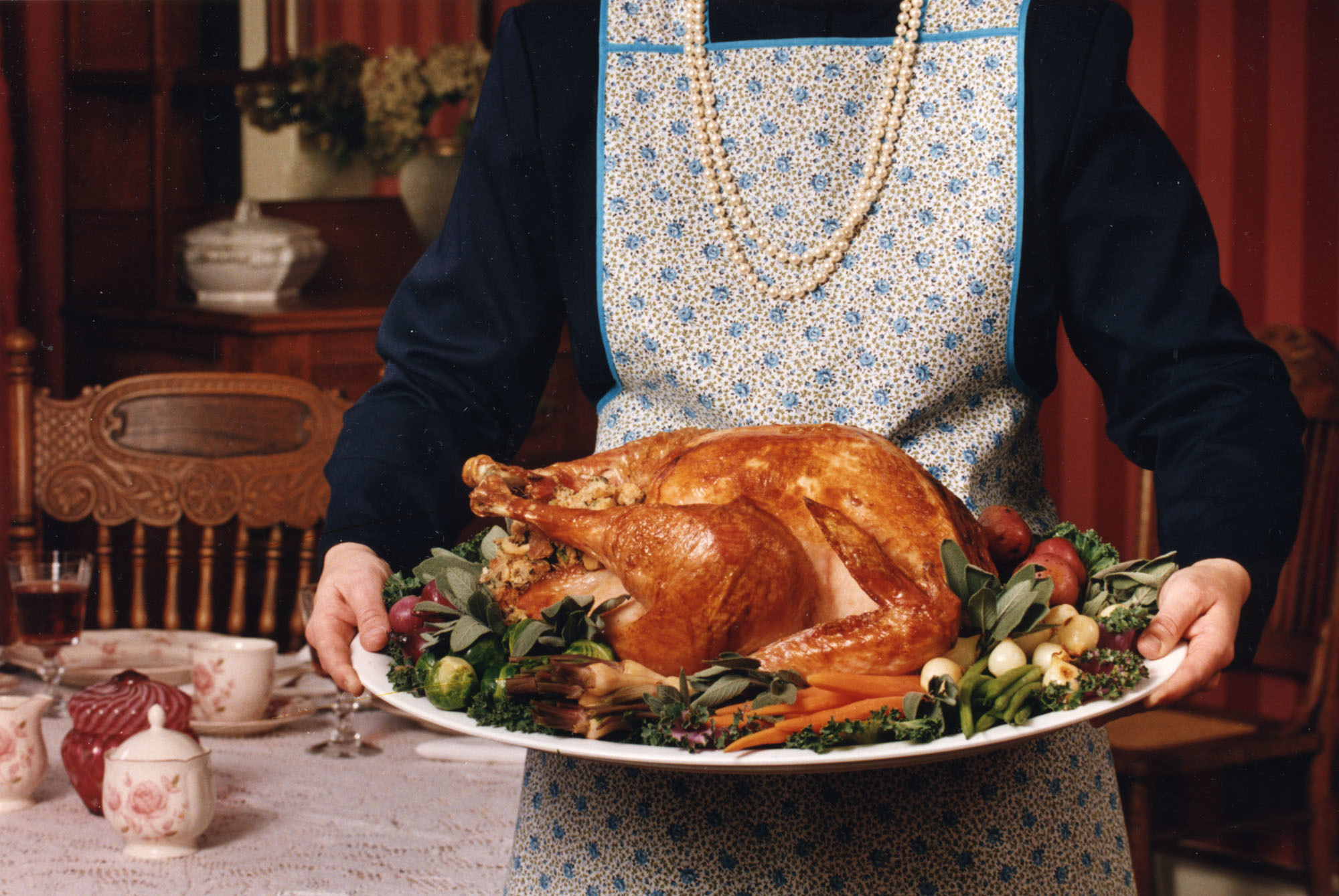 photo of a headless woman holding a Thanksgiving turkey
