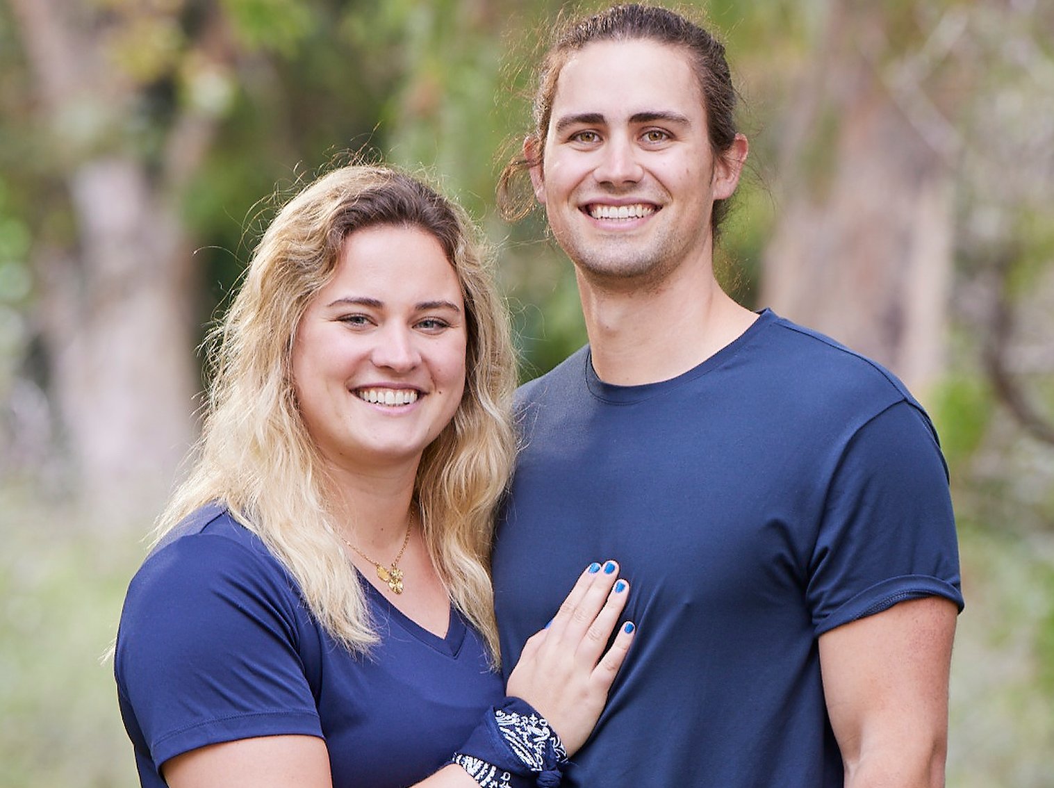 Abby Garrett and Will Freeman pose together in blue shirts on 'The Amazing Race 34'.