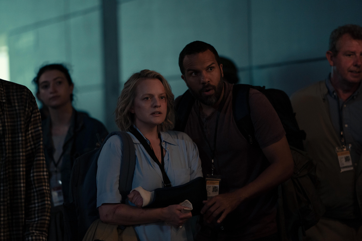 In The Handmaid's Tale, June and Luke stand in line at the train station. June has a broken arm in a cast and sling.