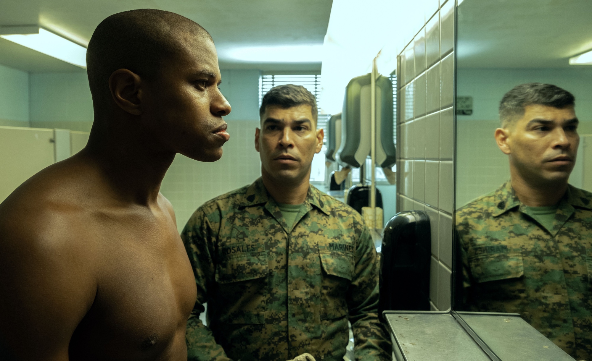 'The Inspection' Jeremy Pope as Ellis French and Raúl Castillo as Rosales. Pope is shirtless looking at himself in the mirror. Castillo is wearing his Marine uniform and looking at him from the side.