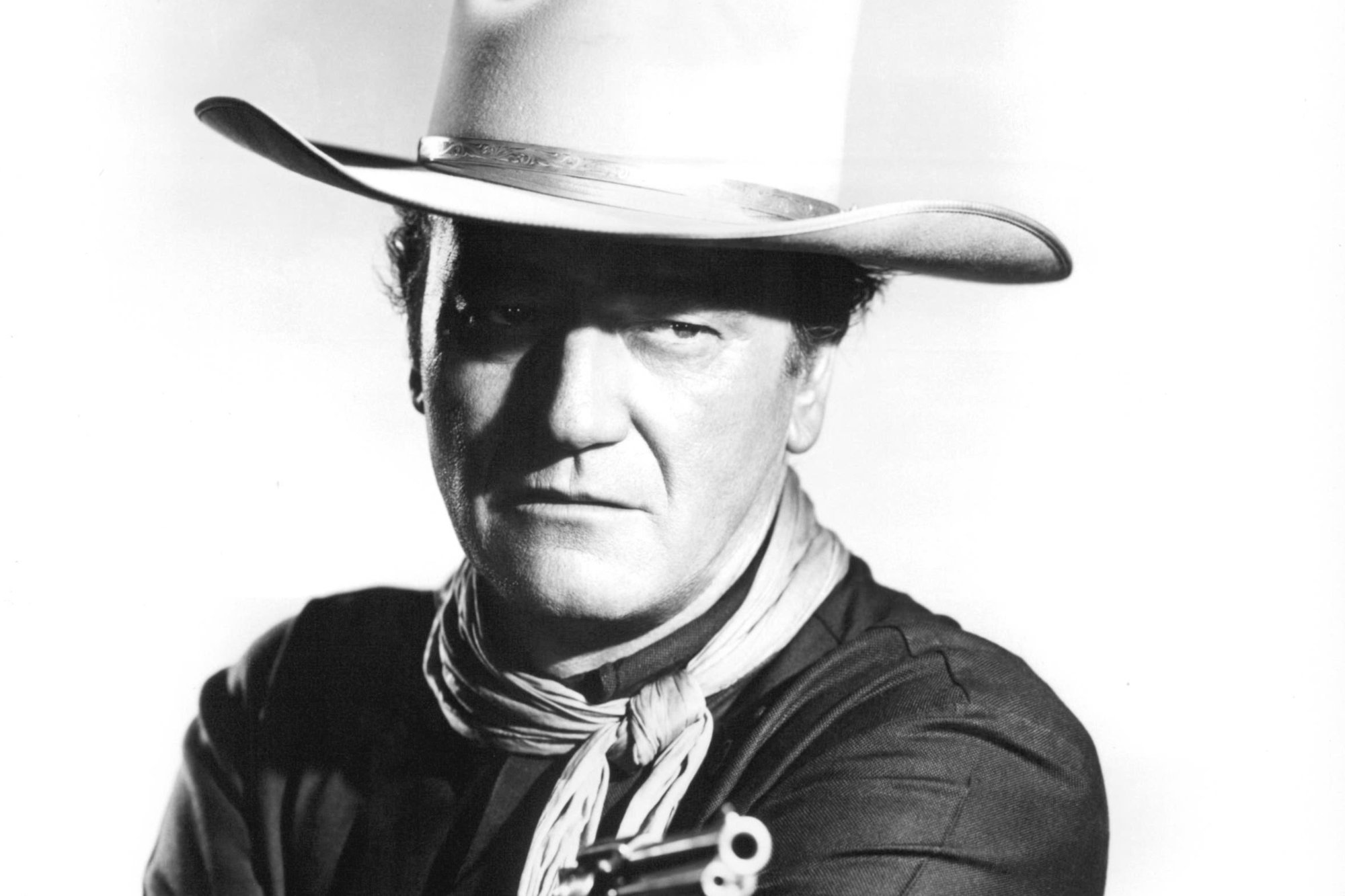 'The Man Who Shot Liberty Valance' actor John Wayne, who 'Family Guy' teased. He's wearing a cowboy hat and holding a gun in a black-and-white picture.