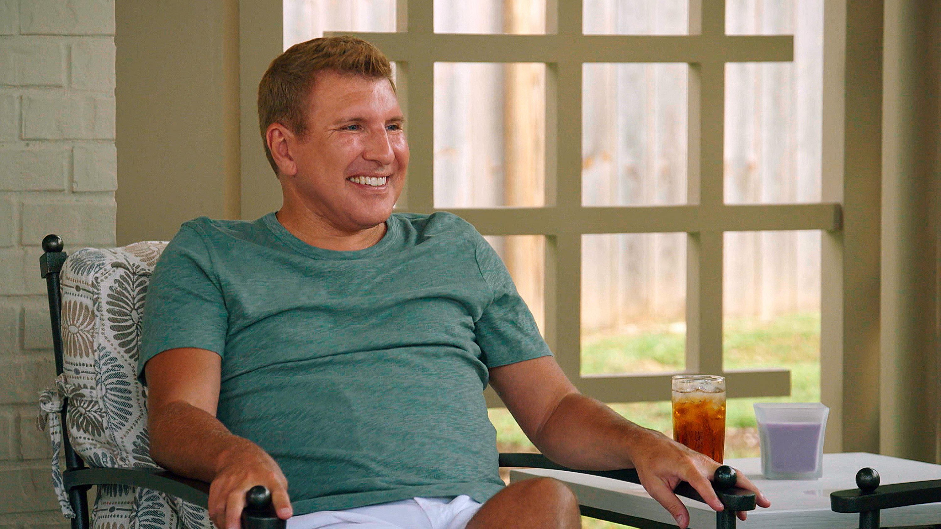 Todd Chrisley smiling and wearing a blue T-shirt on 'Chrisley Knows Best'