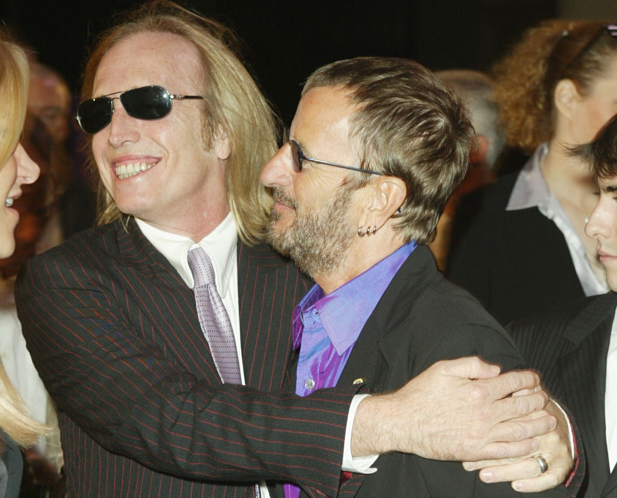Tom Petty wraps his arms around Ringo Starr.
