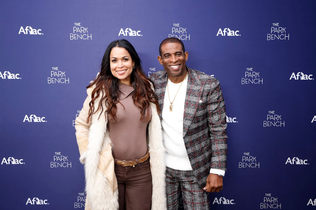 Deion Sanders and Tracey Edmonds smile at a media event in 2022