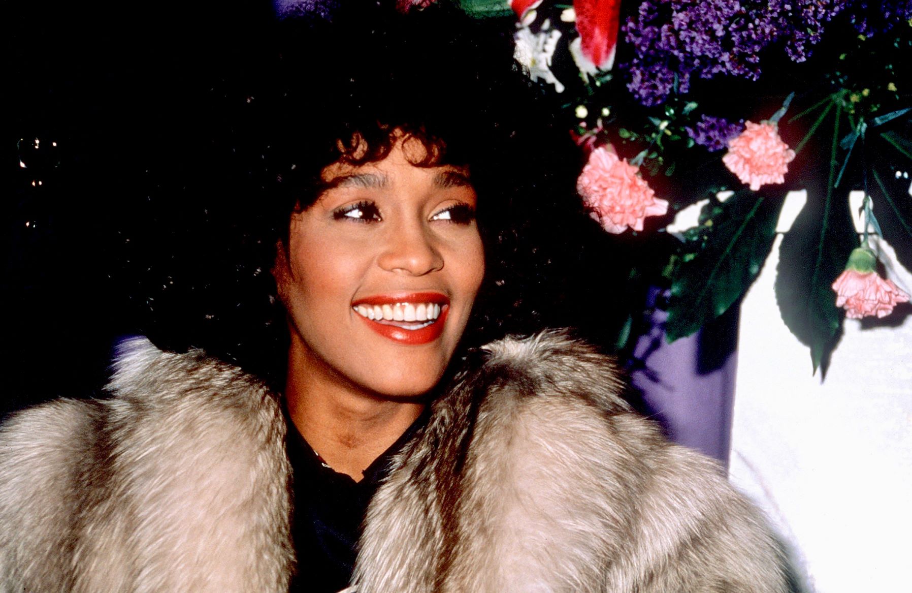 Whitney Houston wearing a coat