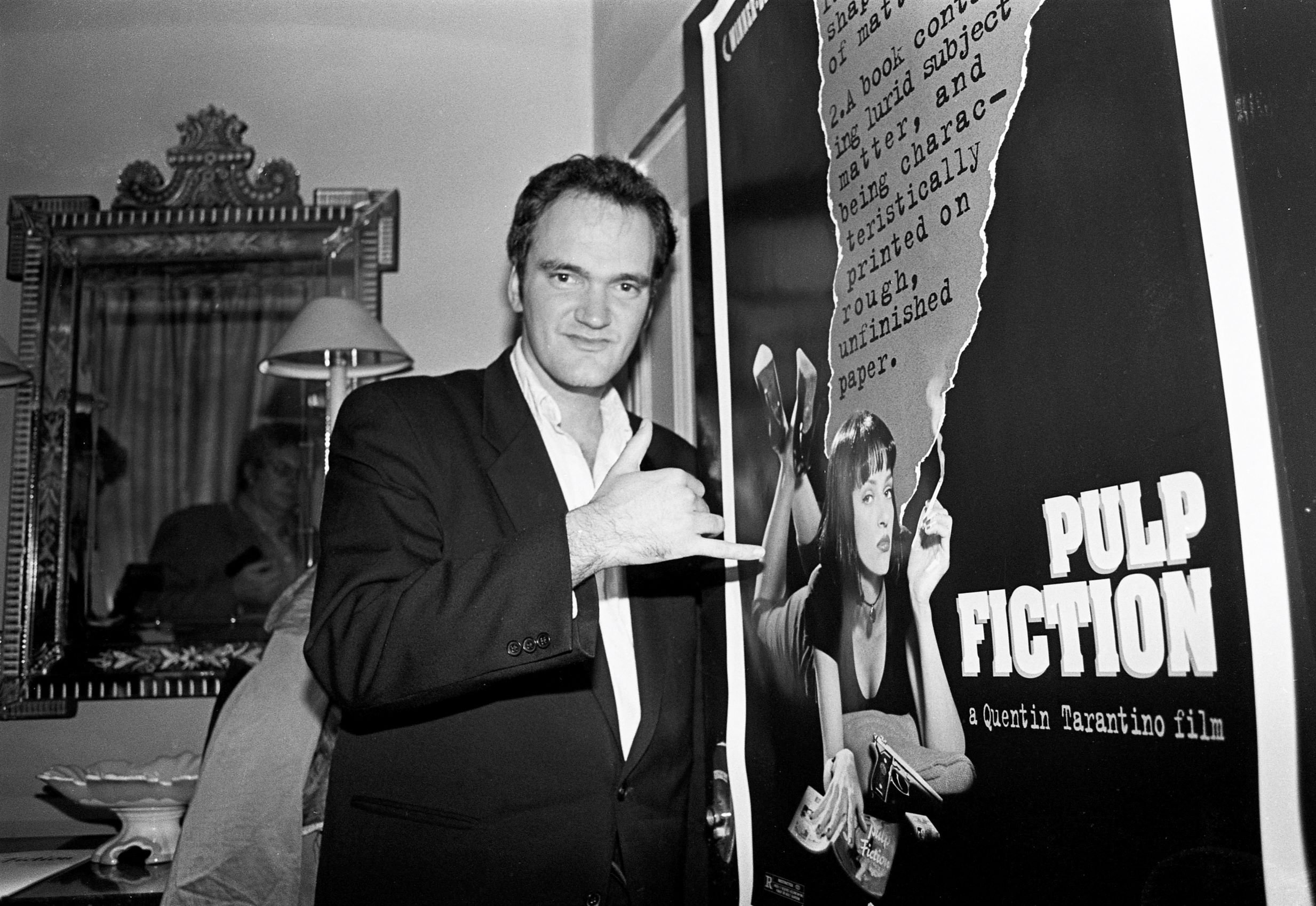 Quentin Tarantino near a poster