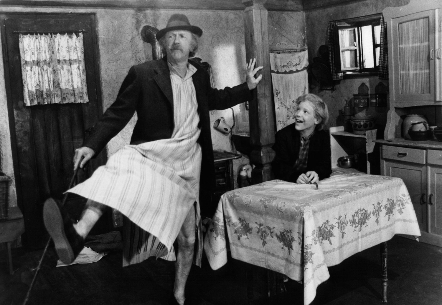 Jack Albertson dancing in front of Peter Ostrum in a scene from the film 'Willy Wonka & the Chocolate Factory'