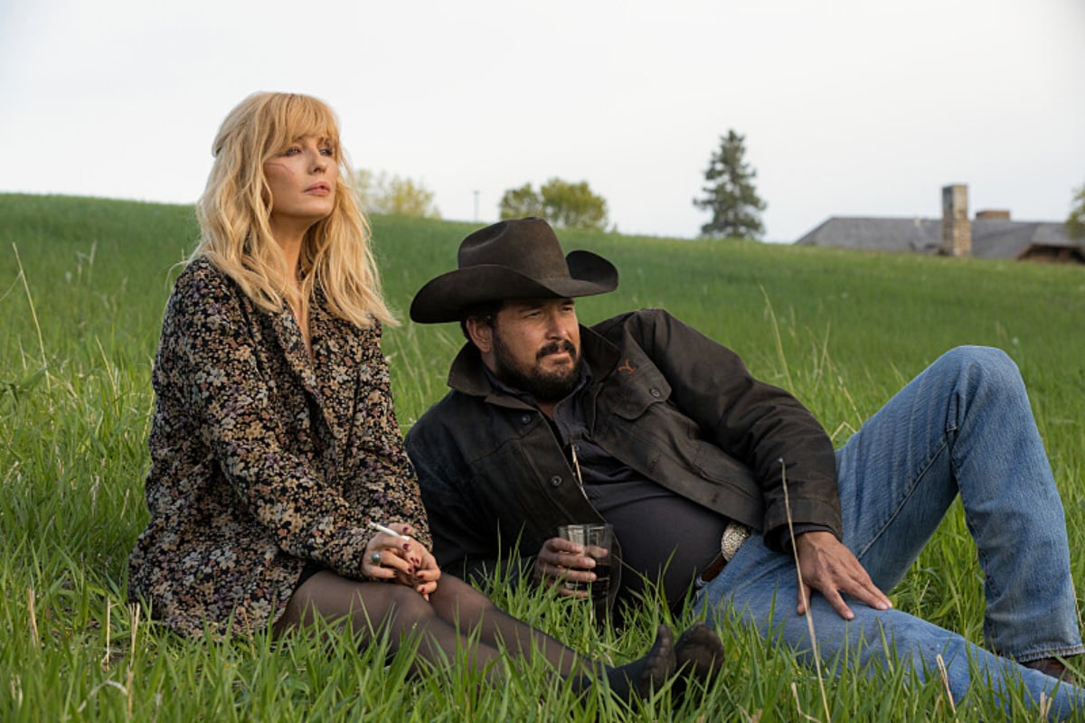 In Yellowstone Season 5, Beth and Rip sit in the grass.