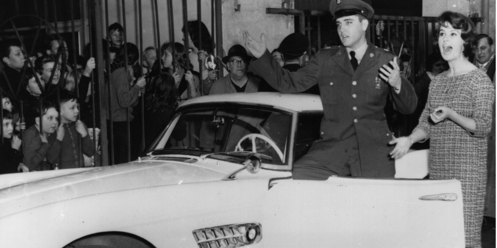 Elvis Presley poses in Germany with a white BMW.