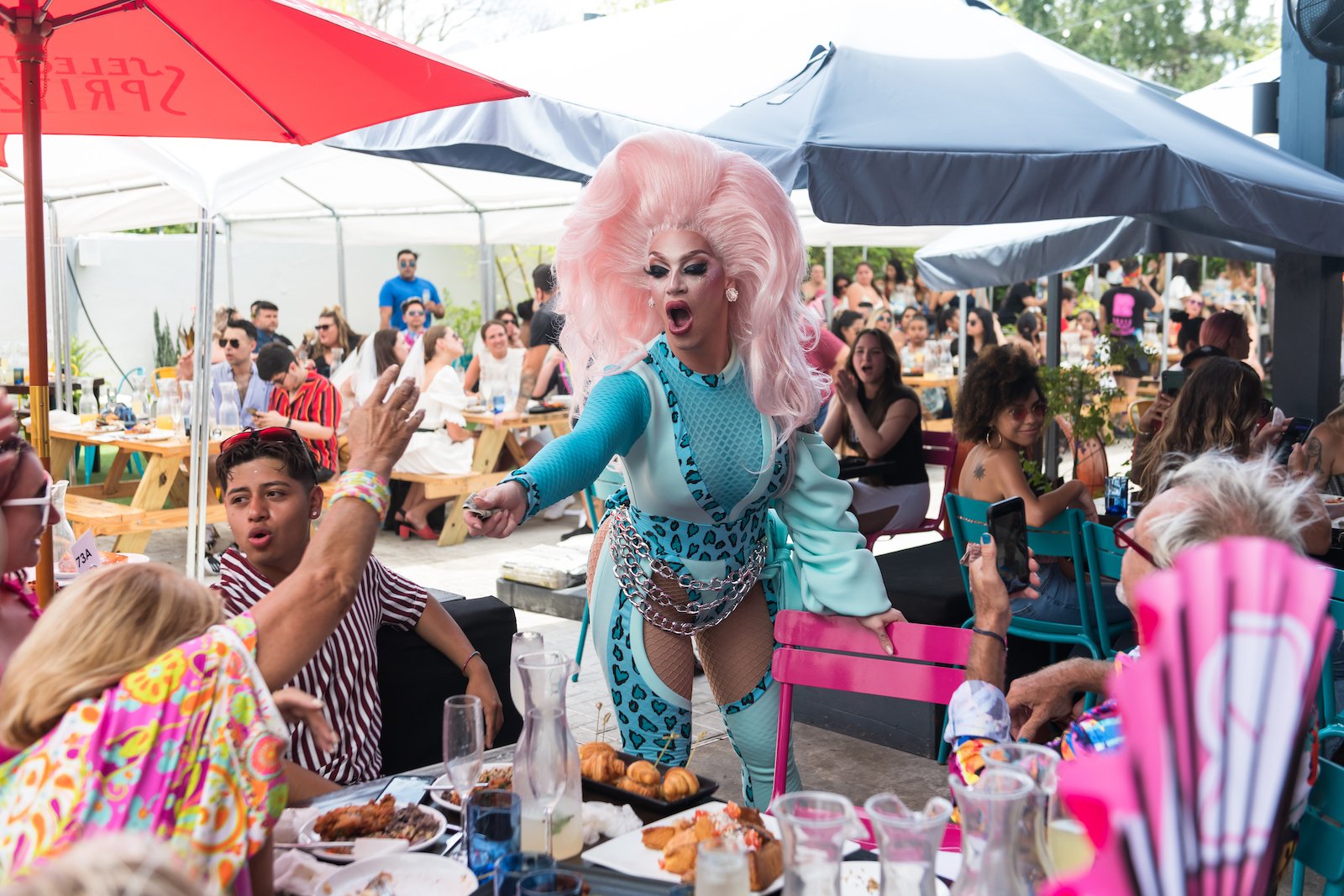 R House drag performer dances in front of a table outside the restaurant as seen in 'Family Karma'