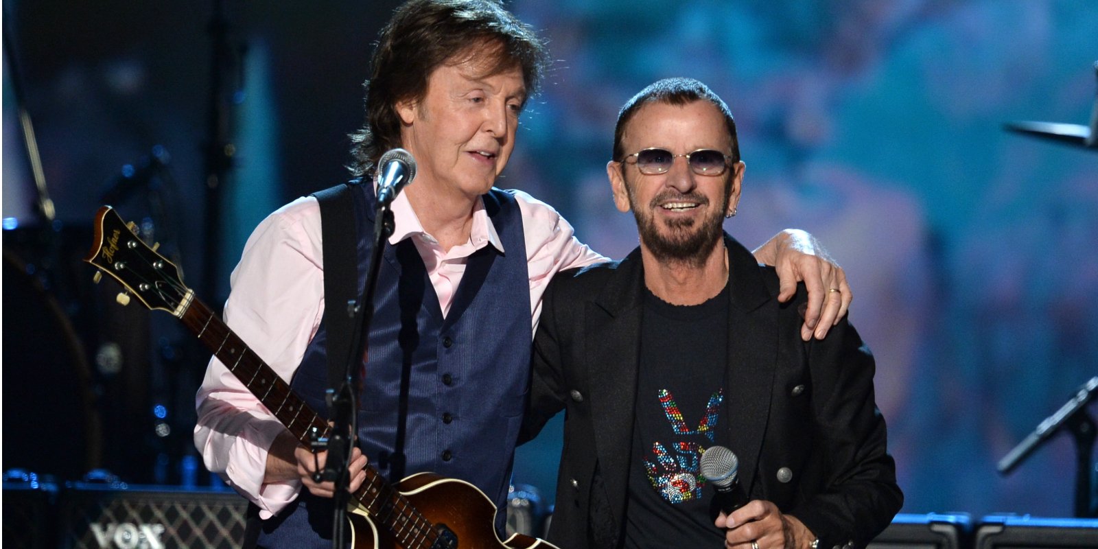 Paul McCartney and Ringo Starr pose together on stage.
