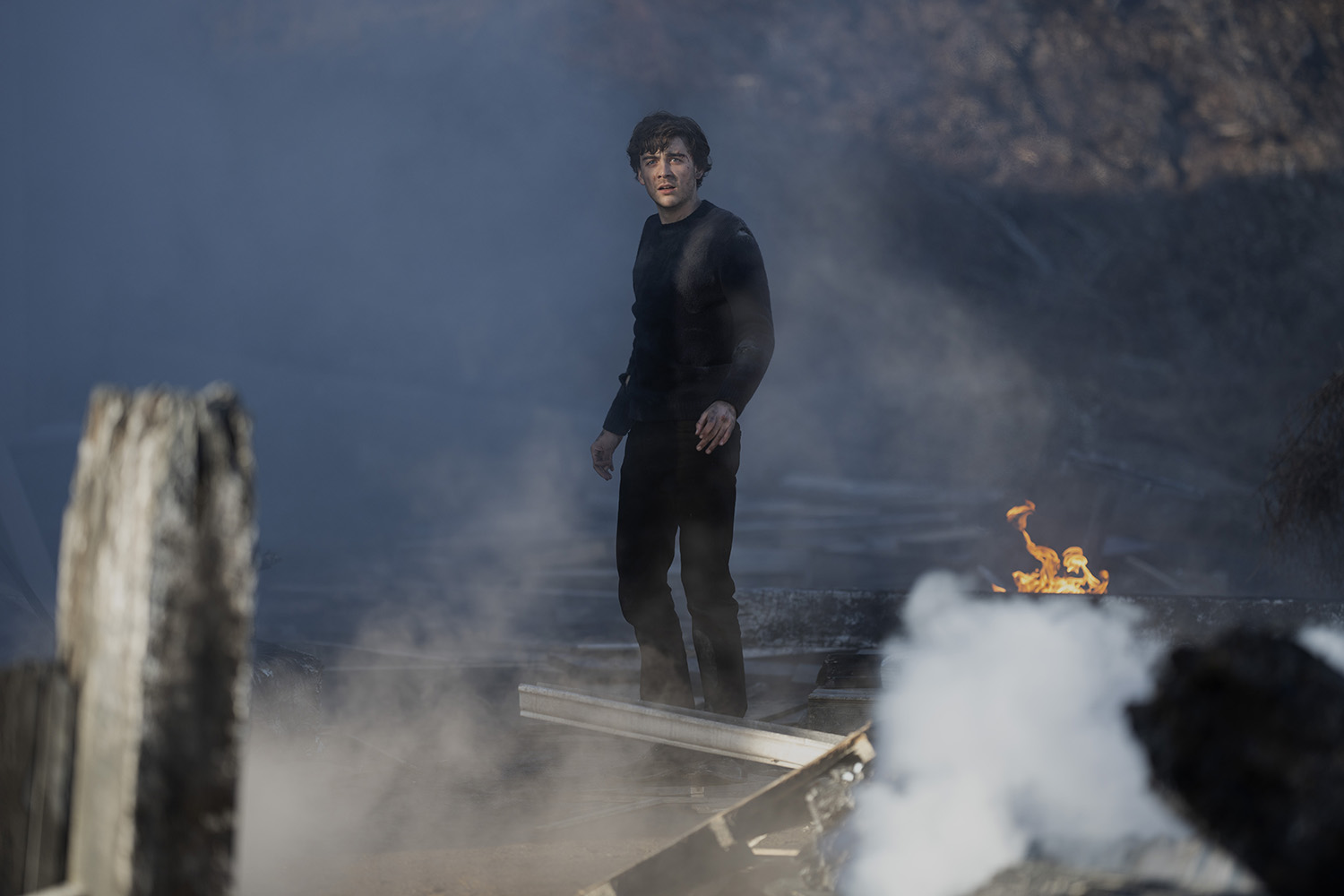 Ty Doran as Cal Stone standing in smoke and debris in Manifest Season 4