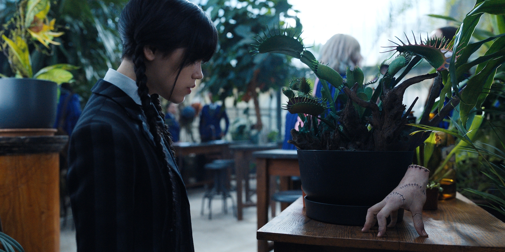 Wednesday (Jenna Ortega) and Thing plotting before her botany class begins.