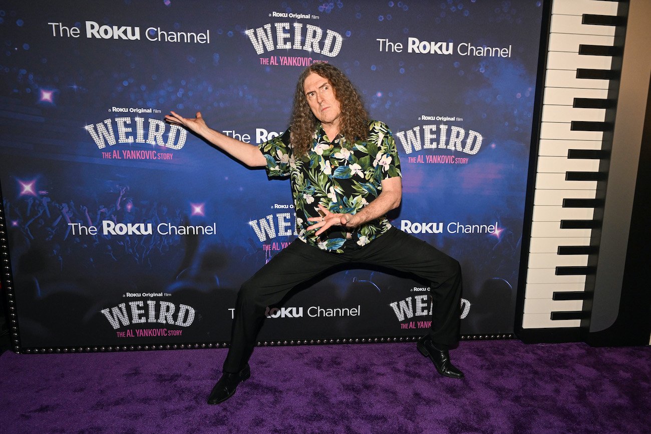Weird Al Yankovic posing in front of the step and repeat for his Roku movie 'Weird: The Al Yankovic Story,' which was inspired by a Funny or Die post from 2010