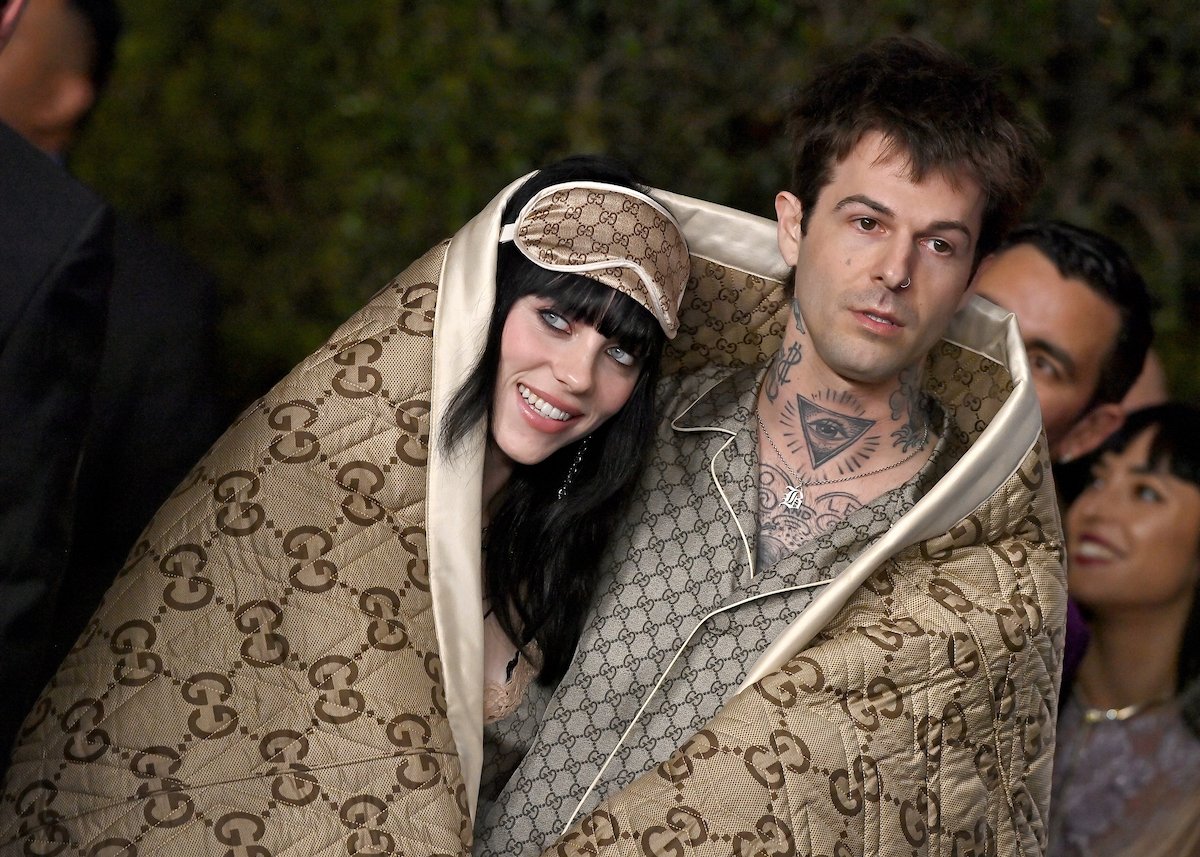 Billie Eilish and her boyfriend, Jesse Rutherford, pose together in matching outfits at an event.
