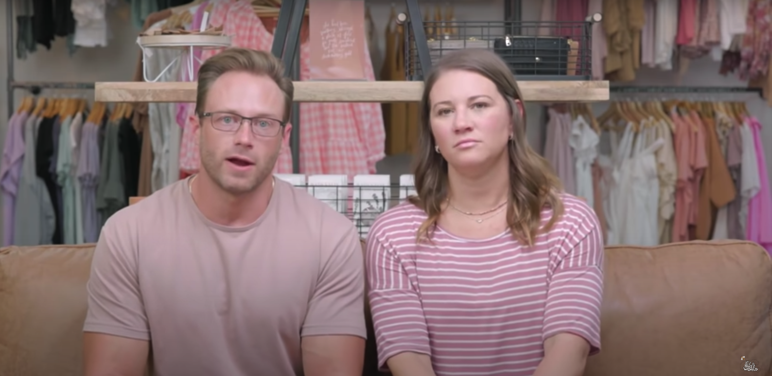 Adam Busby and Danielle Busby of 'OutDaughtered' sitting in front of racks of clothes
