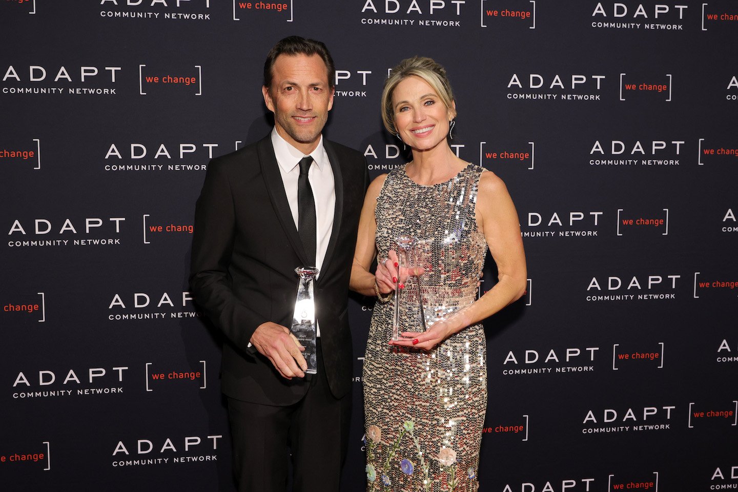 Andrew Shue and Amy Robach from 'Good Morning America' standing next to each other holding awards