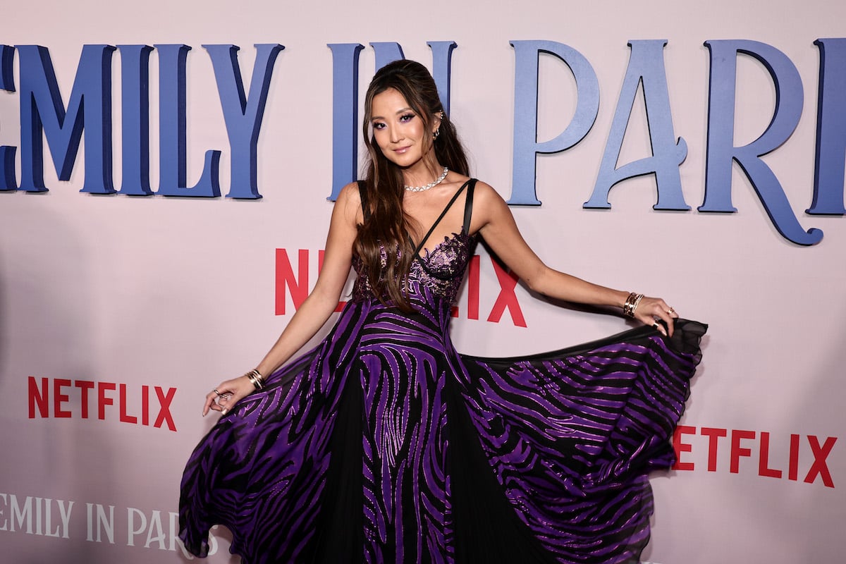 Ashley Park attends the Emily In Paris Red Carpet in a purple dress