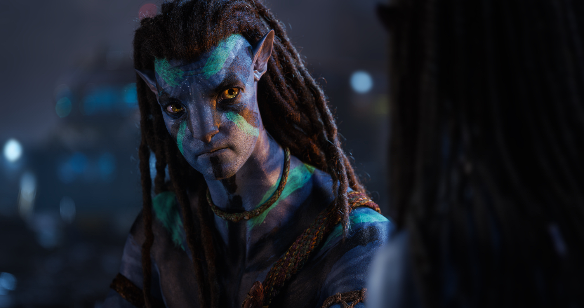 'Avatar: The Way of Water' Jake Sully (Sam Worthington) looks straight ahead with turquoise war paint on his face and body
