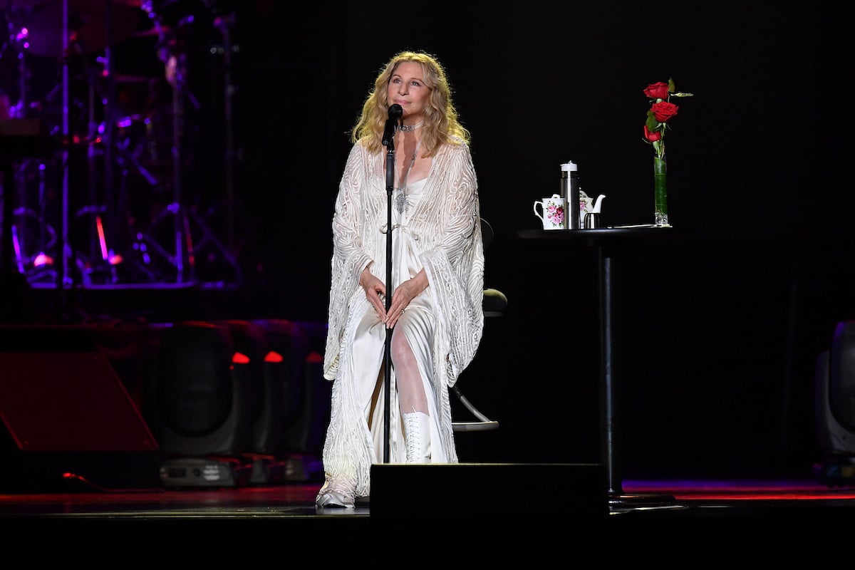 Barbra Streisand appears in concert wearing a white dress.