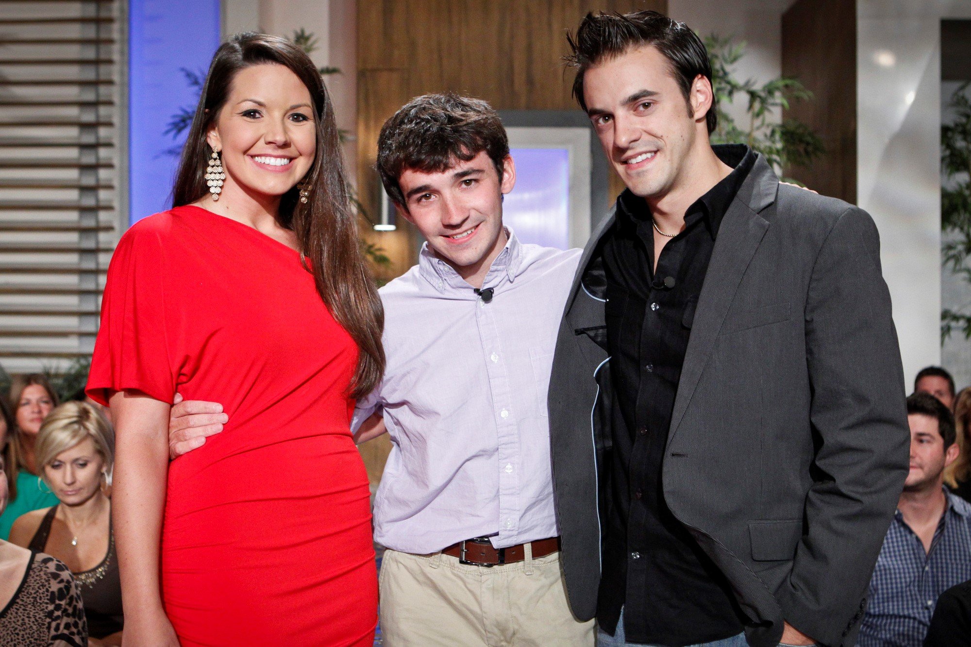 Danielle Murphree, Ian Terry, and Dan Gheesling, who starred in 'Big Brother 14' on CBS, pose for pictures at the finale. Danielle wears a red dress. Ian wears a light blue button-up shirt and khakis. Dan wears a dark gray suit over a black button-up shirt and jeans.