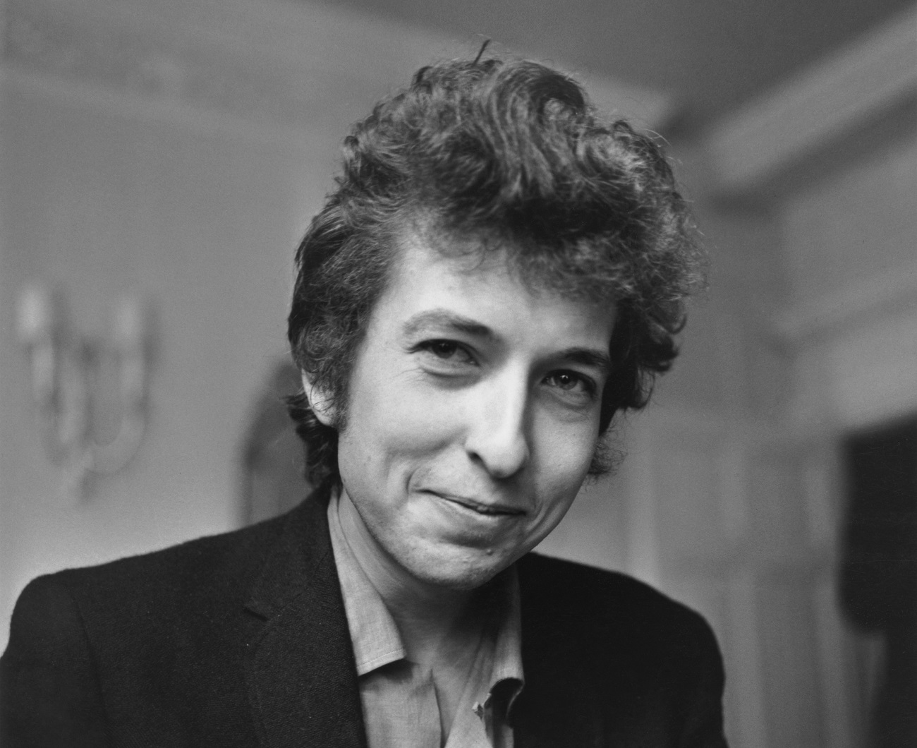 A black and white picture of Bob Dylan smiling.