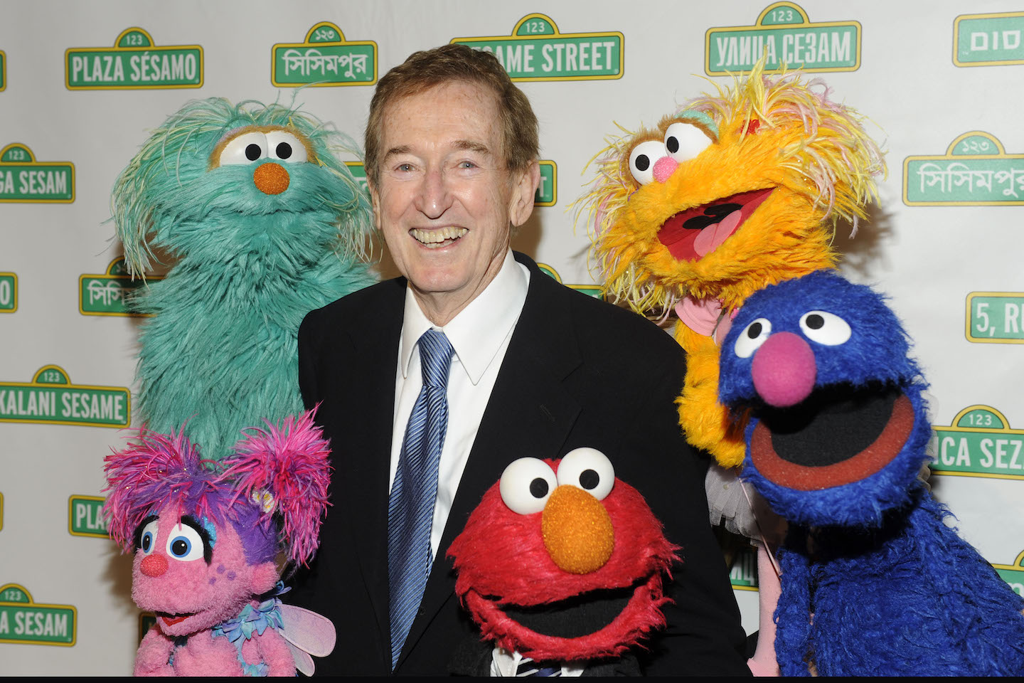 'Sesame Street' star Bob McGrath smiling while surrounded by Muppets