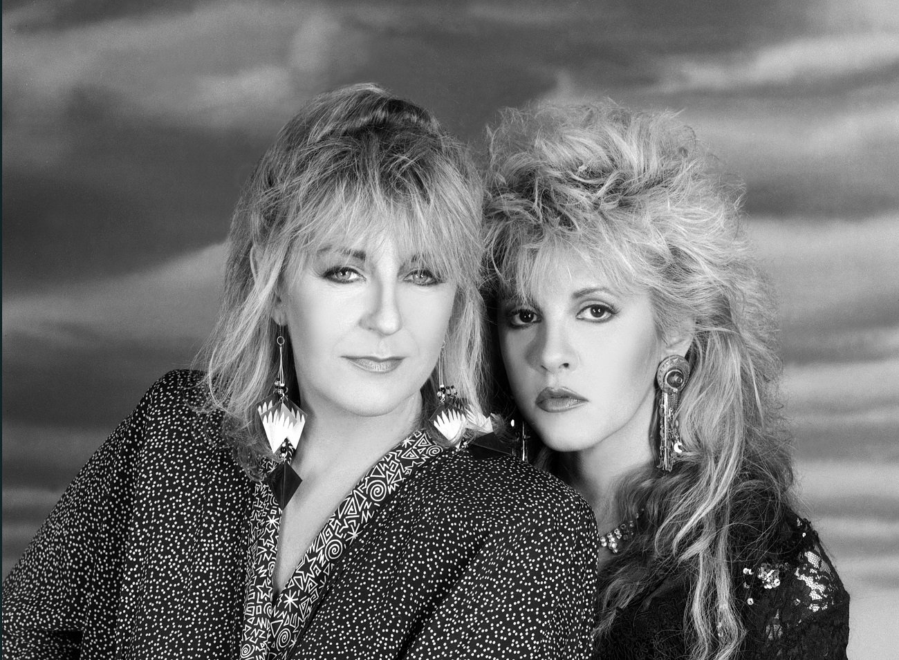 A black and white picture of Stevie Nicks standing slightly behind Christine McVie.