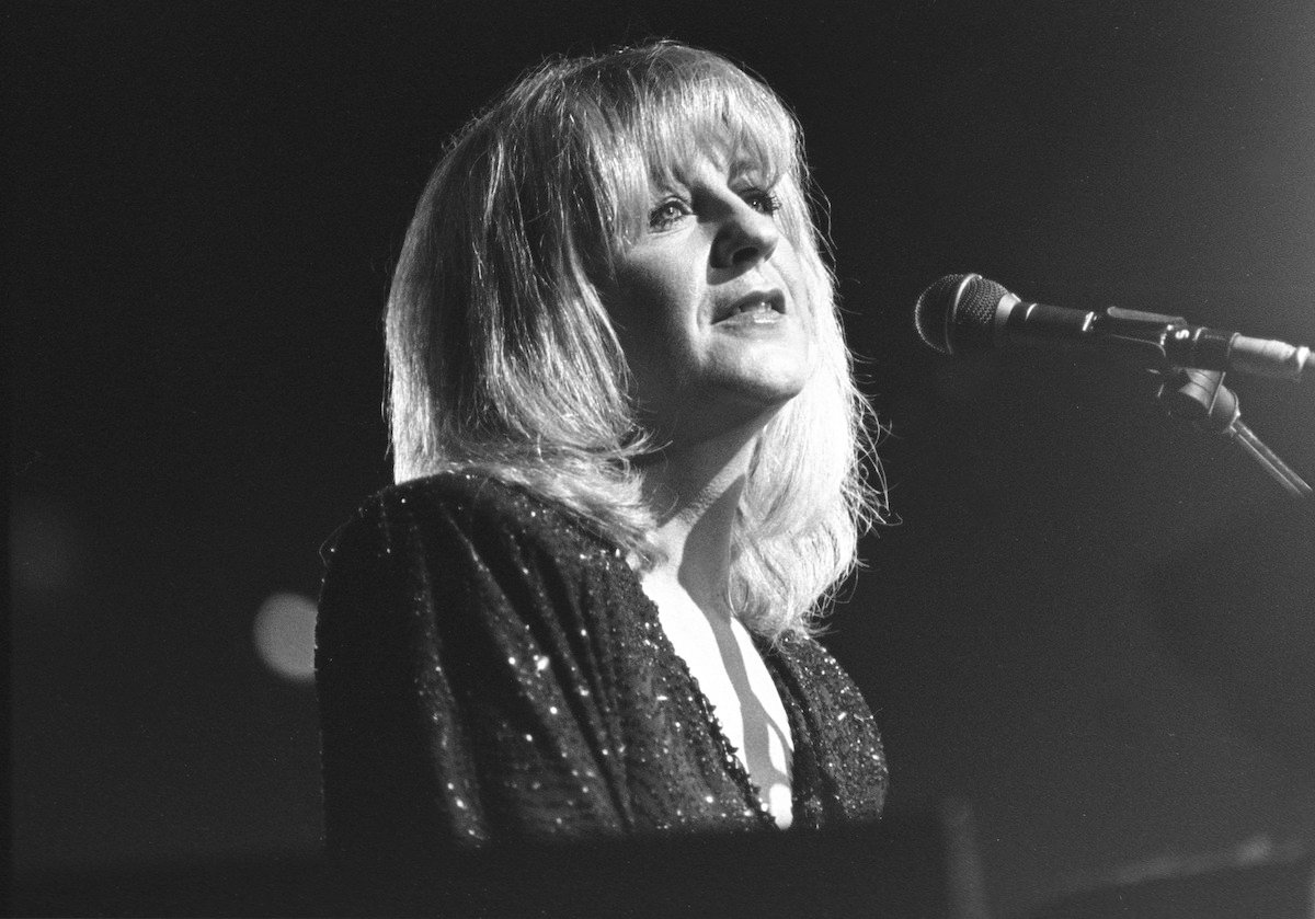 A black and white photo of Fleetwood Mac star Christine McVie, who said her goal was to "stay alive" just months before her death, singing into a microphone.