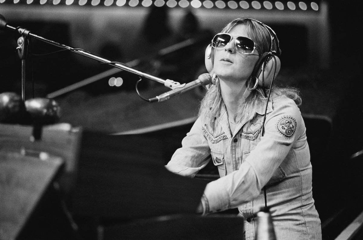 Fleetwood Mac keyboardist Christine McVie, who once called herself a "fly in a jam jar," performs on stage wearing sunglasses.