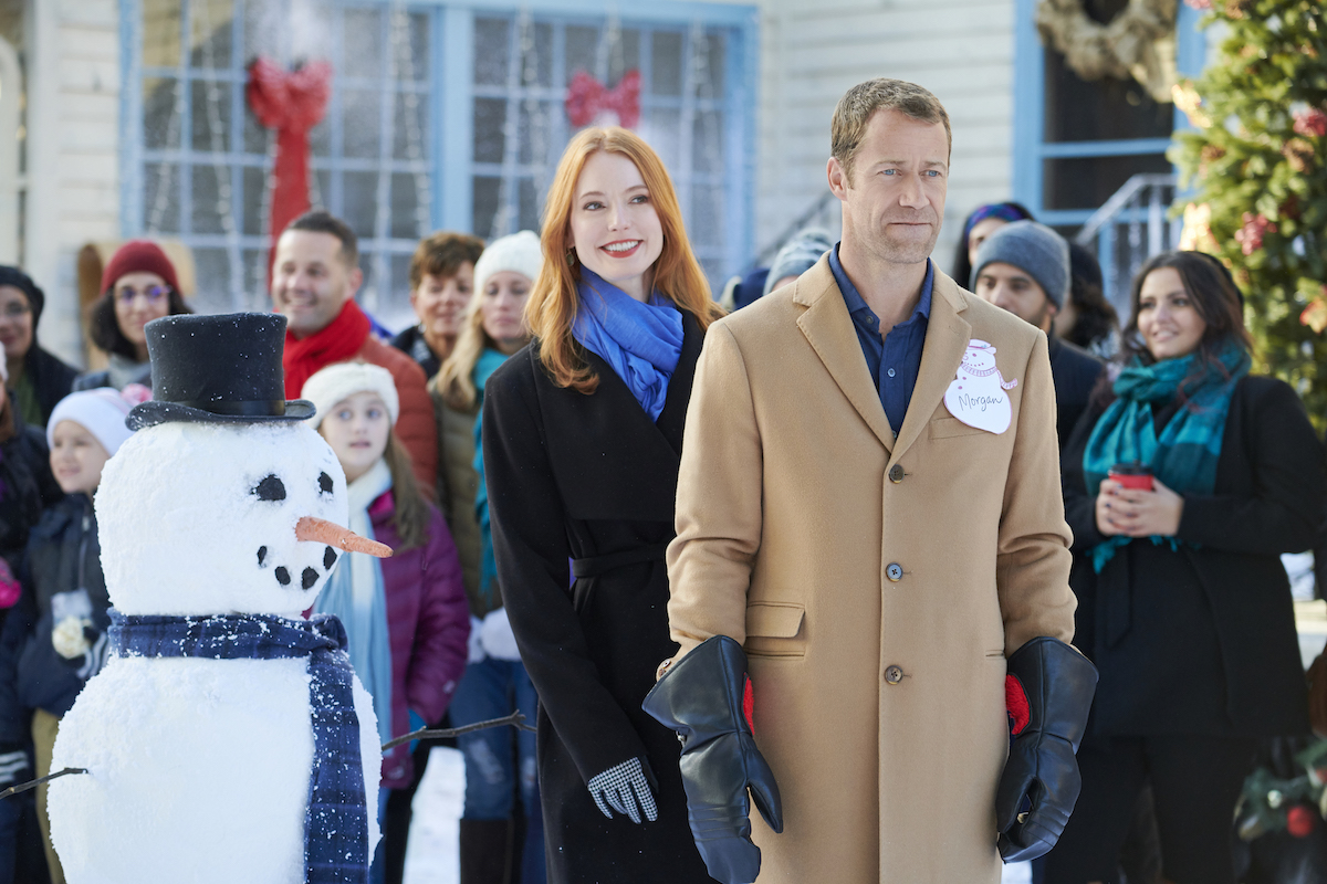 Alicia Witt and Colin Ferguson standing outside in the Hallmark movie 'Christmas on Honeysuckle Lane'