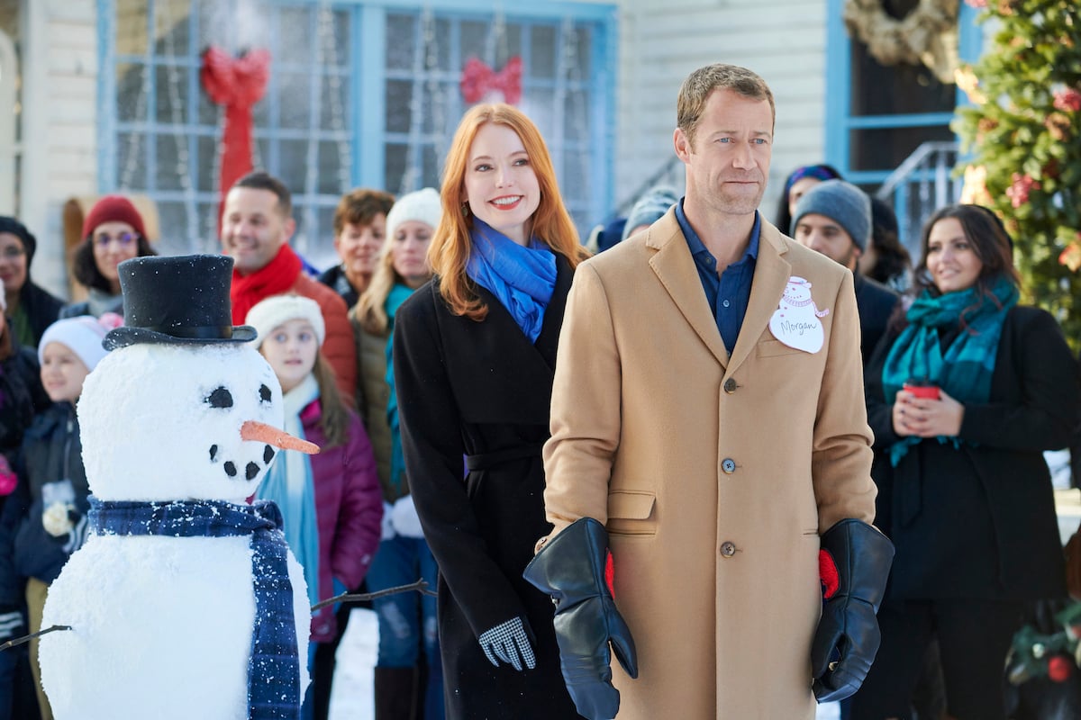 Alicia Witt and Colin Ferguson standing outside in the Hallmark movie 'Christmas on Honeysuckle Lane'