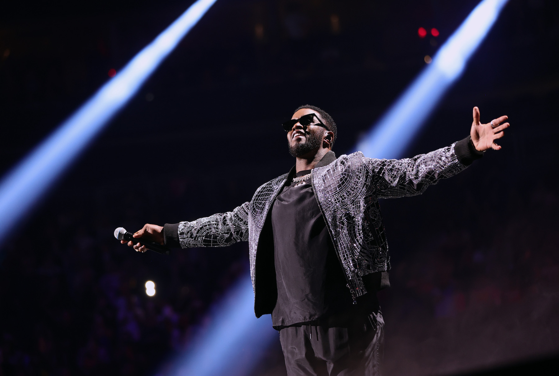 Sean “Diddy" Combs, known for throwing big parties, on stage with his arms spread
