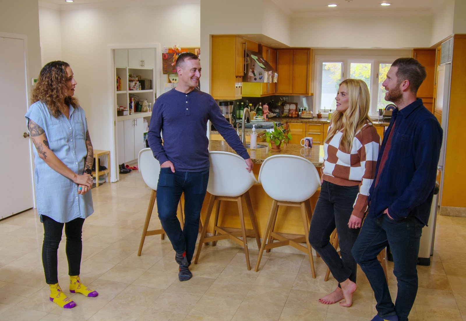 Syd and Shea McGee and their clients in 'Dream Home Makeover' Season 4 on Netflix. They're standing in a kitchen and talking.