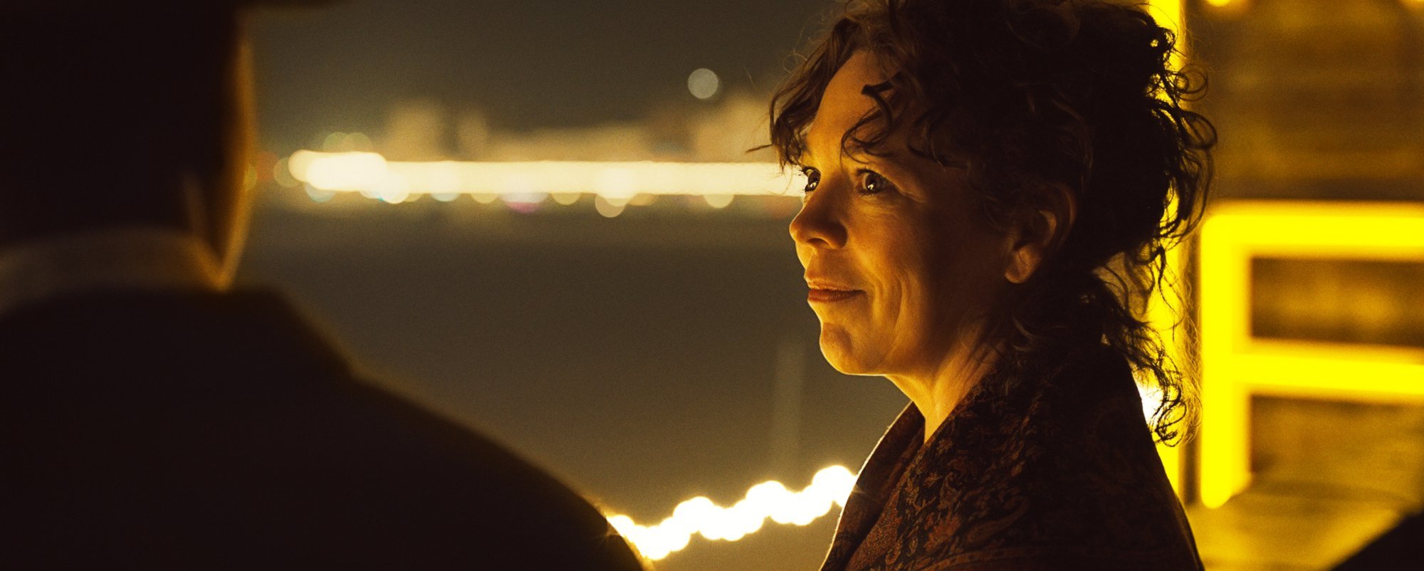 'Empire of Light' Olivia Colman as Hilary looking at Micheal Ward as Stephen, shown from behind. They're standing on a rooftop.