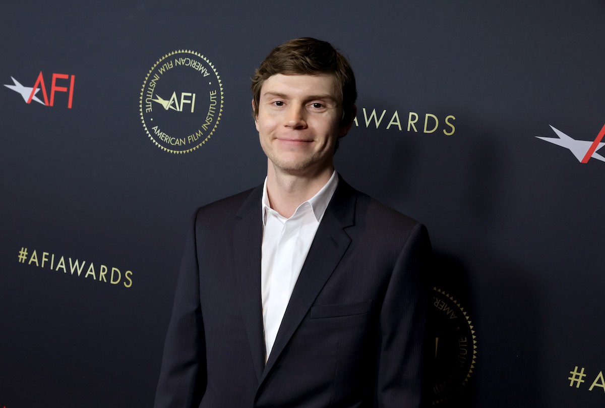 Evan Peters, who played Jeffrey Dahmer in a Ryan Murphy production, smiles and poses at an event.