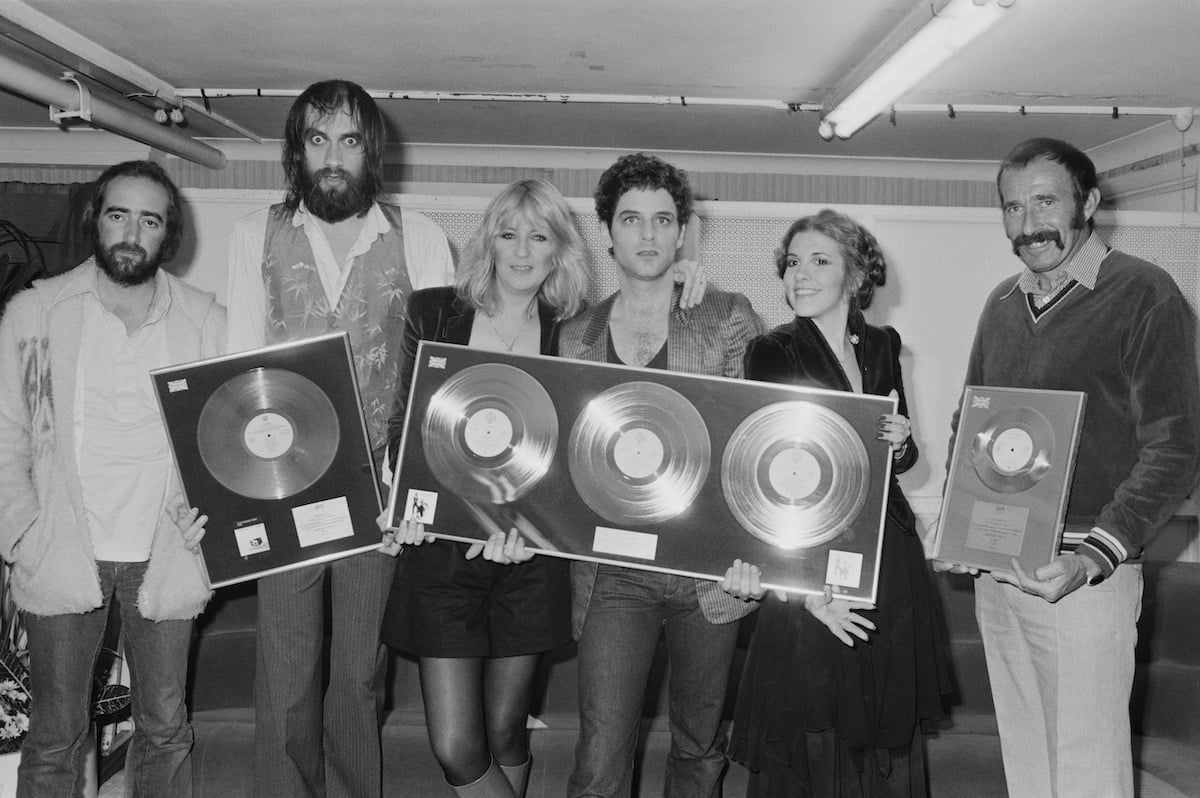 Fleetwood Mac stars John McVie, Mick Fleetwood, Christine McVie, Lindsey Buckingham, and Stevie Nicks hold awards together.