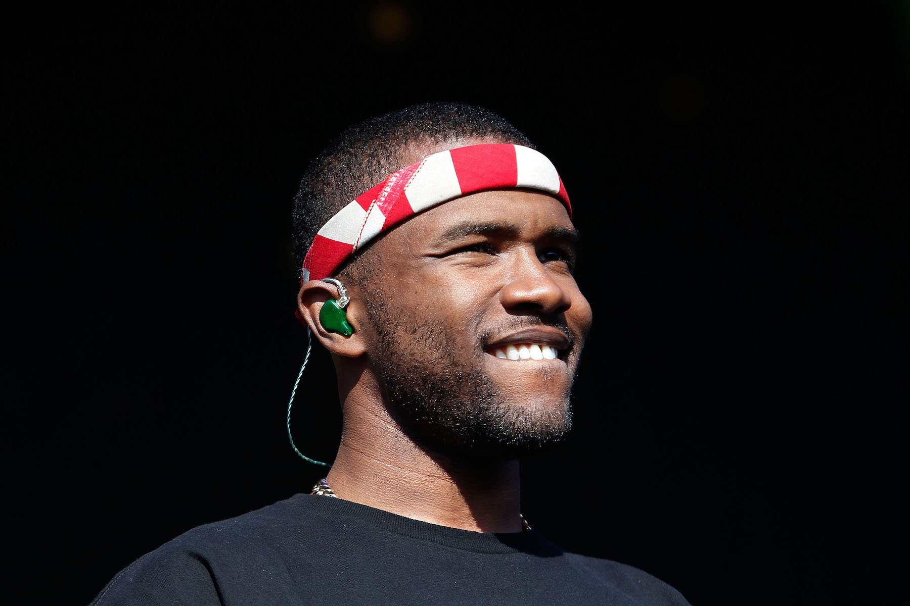 Frank Ocean, once believed to be retiring, smiling wearing a red striped bandana