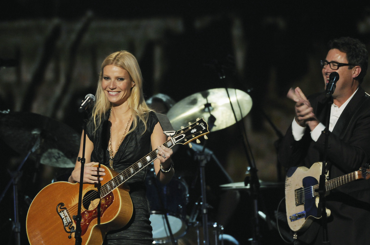 Gwyneth Paltrow accepts applause at the 2010 CMA Awards alongside Vince Gill