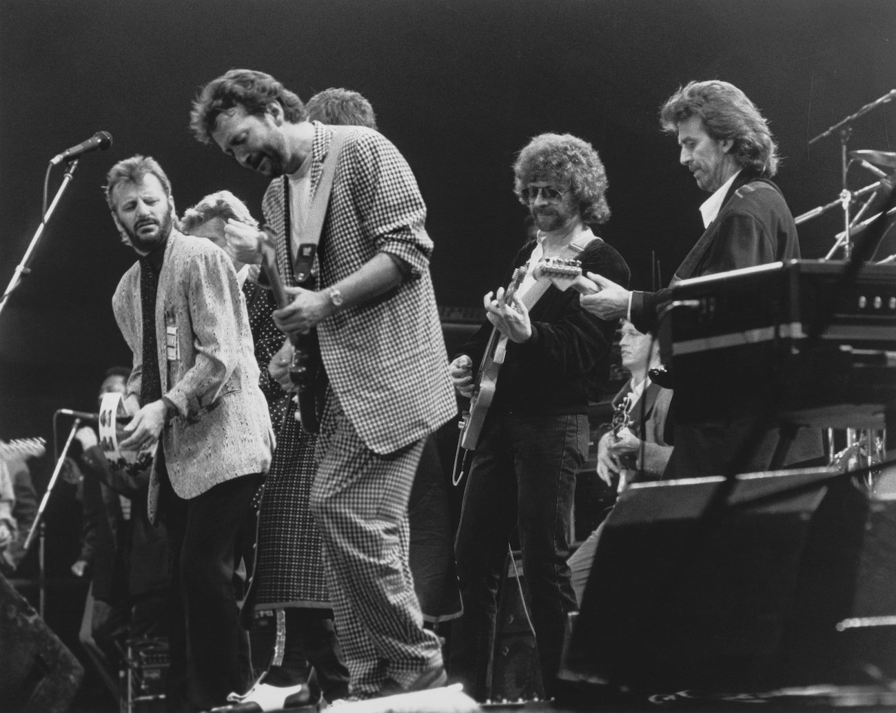 Ringo Starr, Eric Clapton, Jeff Lynne, and George Harrison performing at the Prince's Trust Concert in 1987.