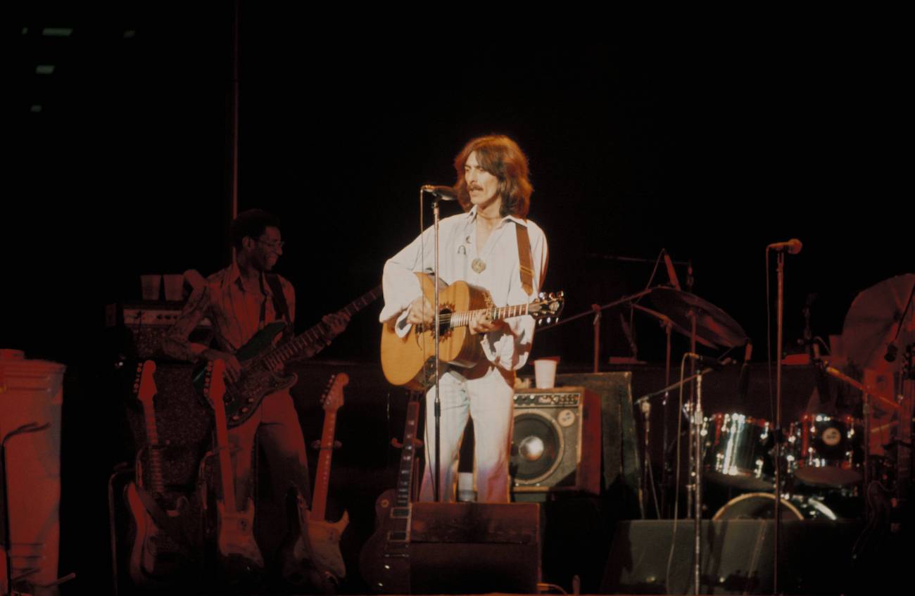 George Harrison playing guitar with Willie Weeks in the background during his 1974 Dark Horse tour. 